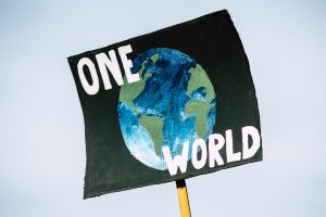 Pancarta que reza "One World" (Un planeta)